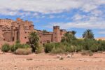 Kasbah walls of Aït Ben Haddou behind palm trees